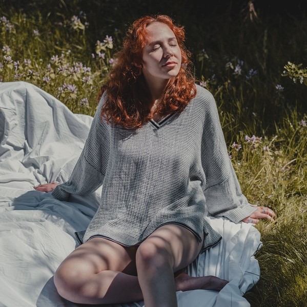 woman demonstrates deep breathing outdoors, one of the best relaxation exercises for anxiety