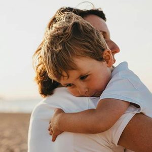 young-boy-hugging-mum-on-beach